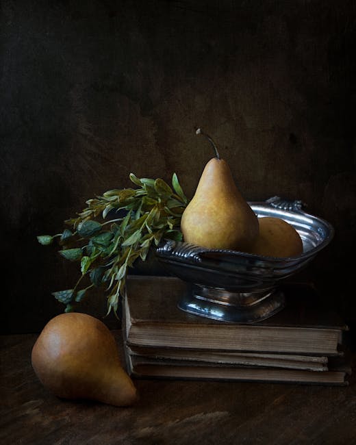 Elegant still life featuring ripe pears and vintage books in a moody setting.